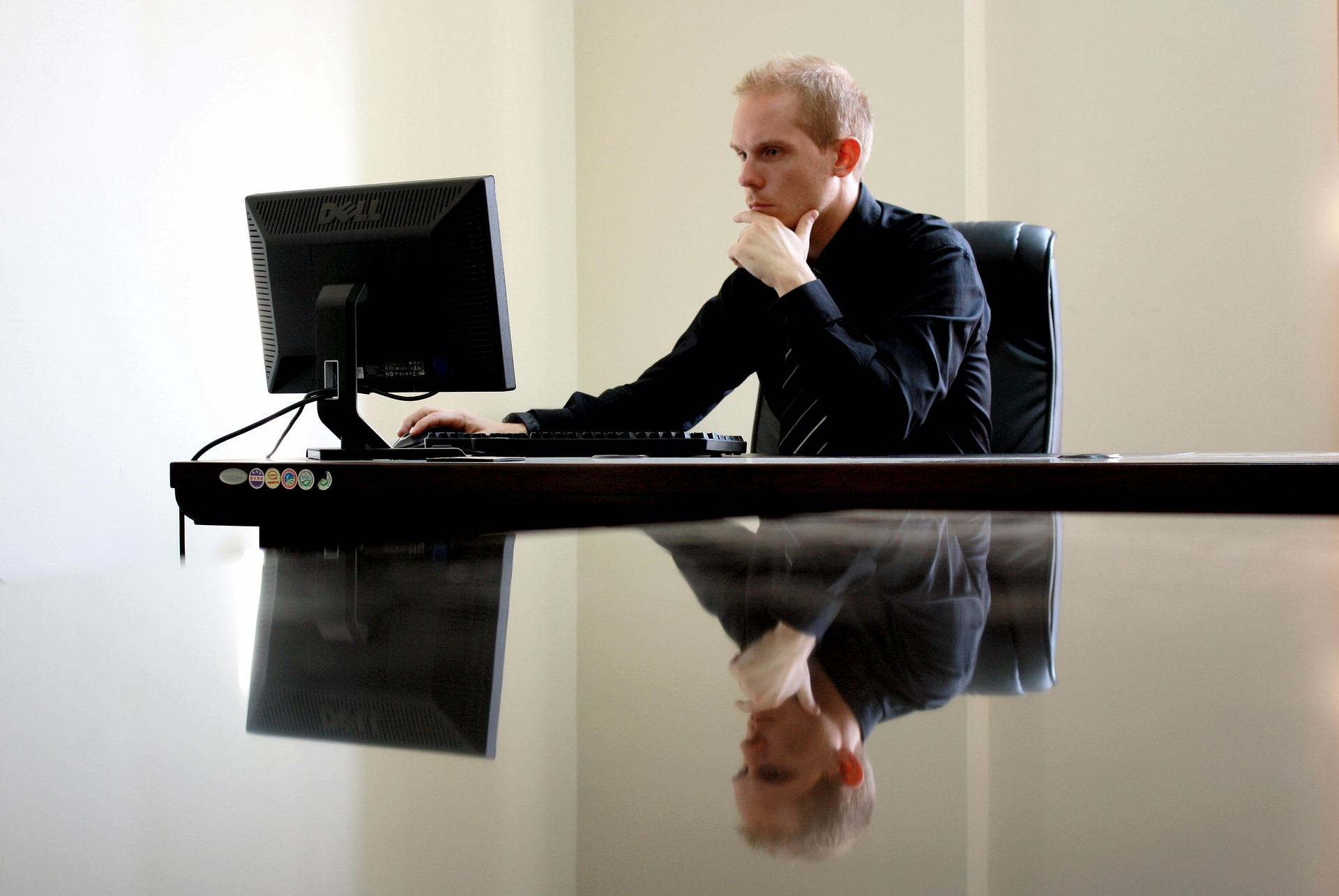 man achter bureau achter beeldscherm